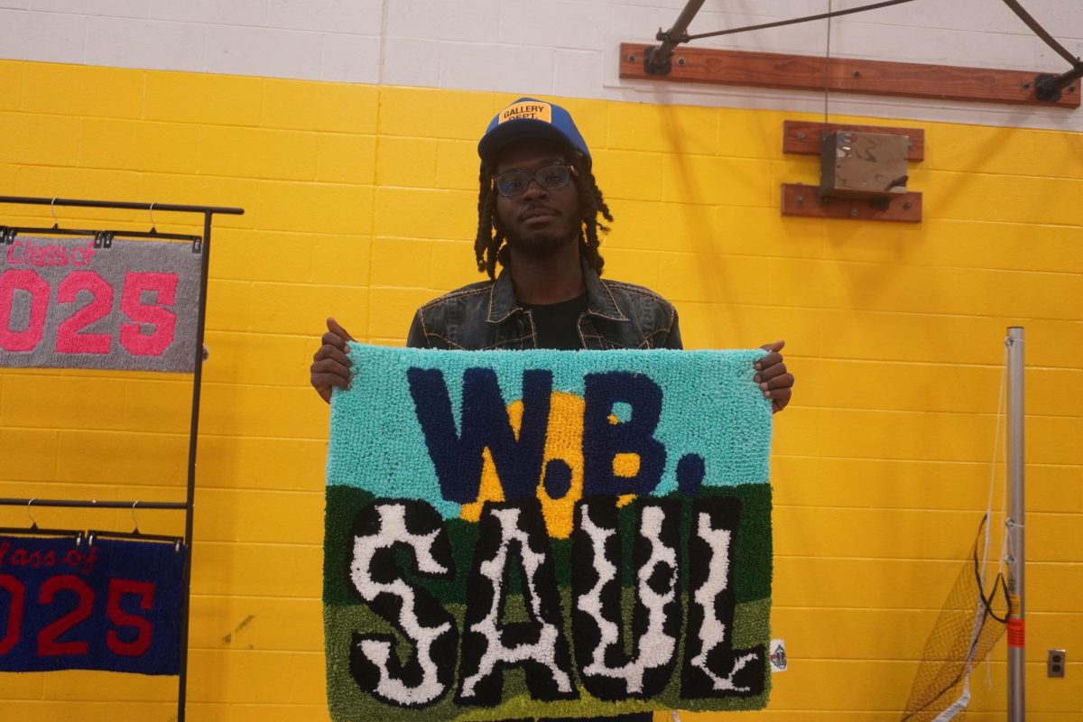 Vender holding up W. B. Saul carpet that he made